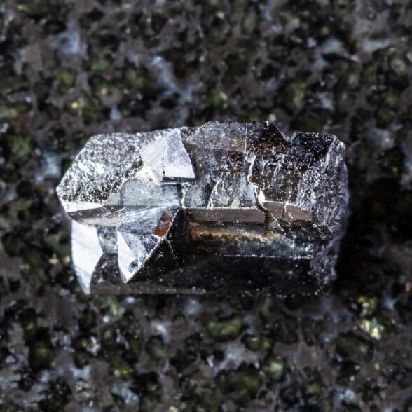 sample of rough ilvaite mineral on black granite background close up from Dalnegorsk, Primorye, Russia